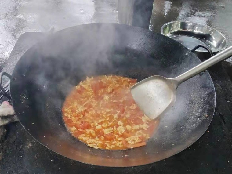 팬에서 토마토와 달걀을 함께 볶는 조리 과정
